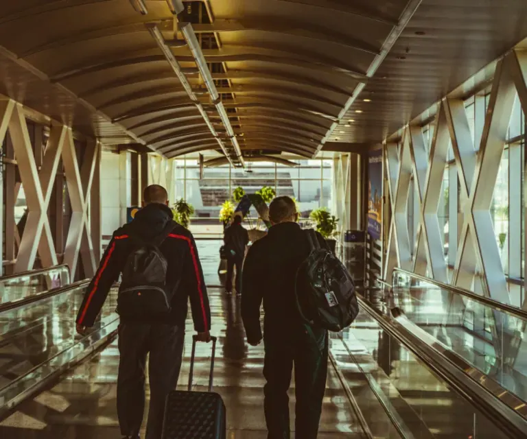 Viajantes de trabalho com malas de rodinha no corredor do aeroporto